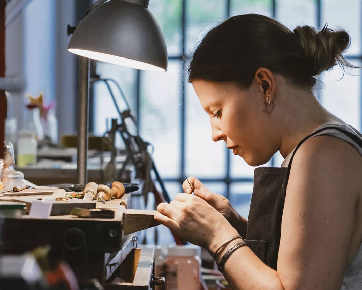 An artisan at a jeweler’s bench on a custom diamond engagement ring